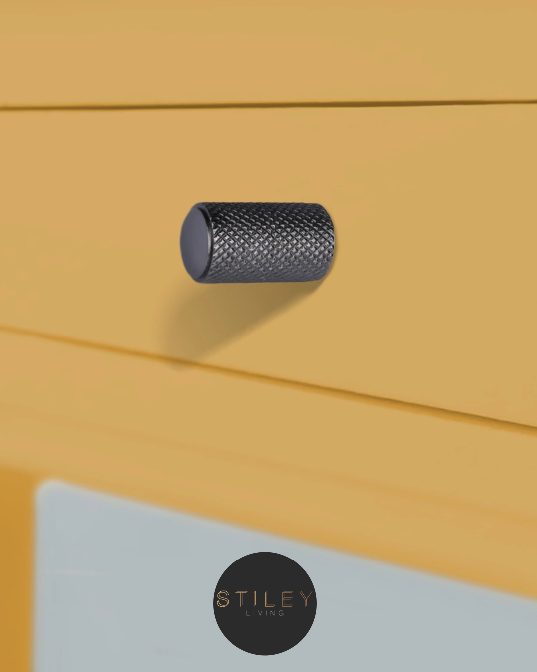 Knurled cabinet knob on a mustard yellow cabinet draw